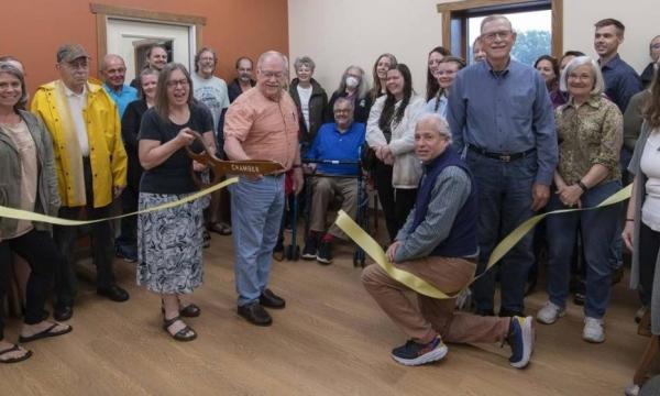 Photo of group of people cutting a ribbon.