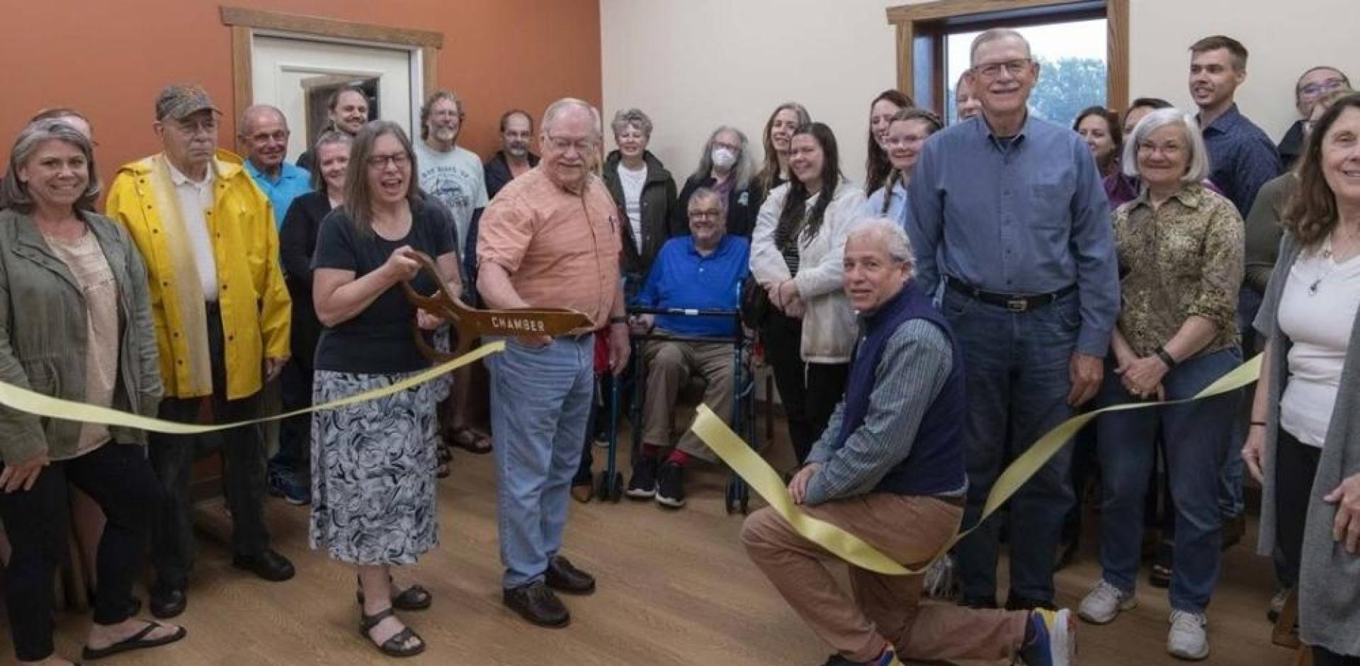 Photo of group of people cutting a ribbon.